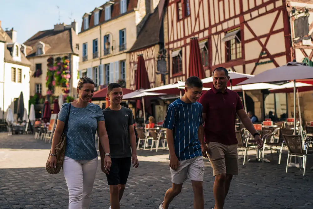 une famille se promène dans la vieille ville de Dijon, en été.