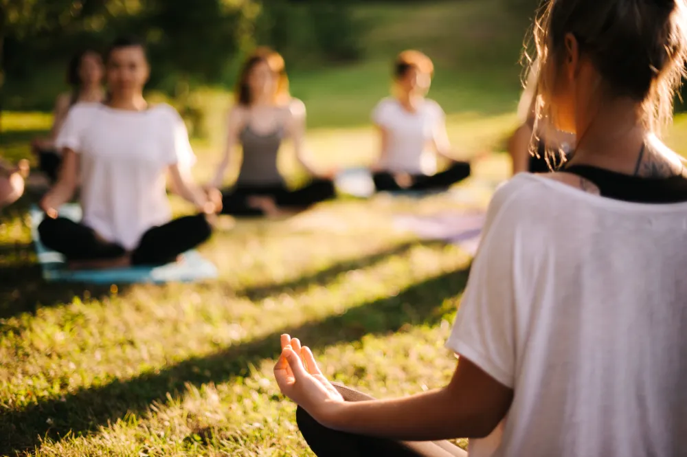 groupe en train de faire du yoga en extérieur