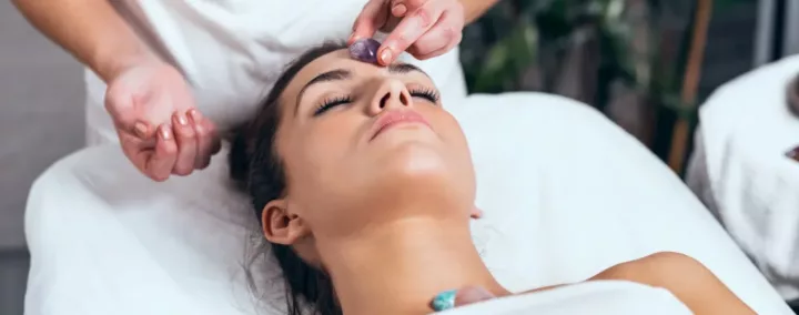 femme en train de recevoir un soin avec des pierres, allongée sur le dos