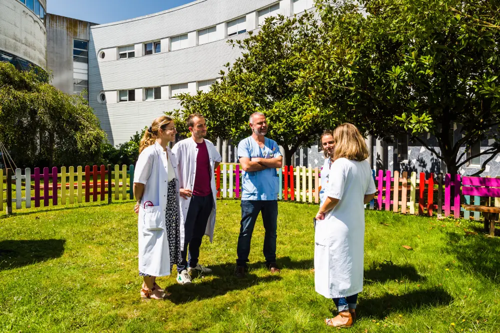 4 membres des équipes soignantes de l'hôpital Yves Le Foll de Saint-Brieuc, en train de discuter devant le bâtiment, au soleil.