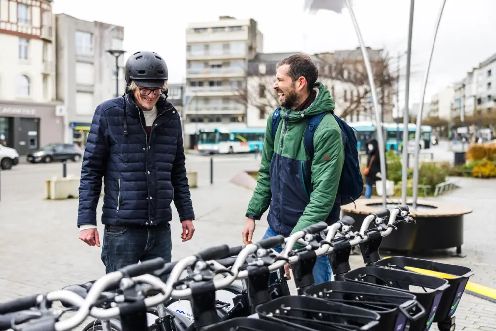 deux hommes devant une station de vélos en libre-service à Saint-Brieuc.
